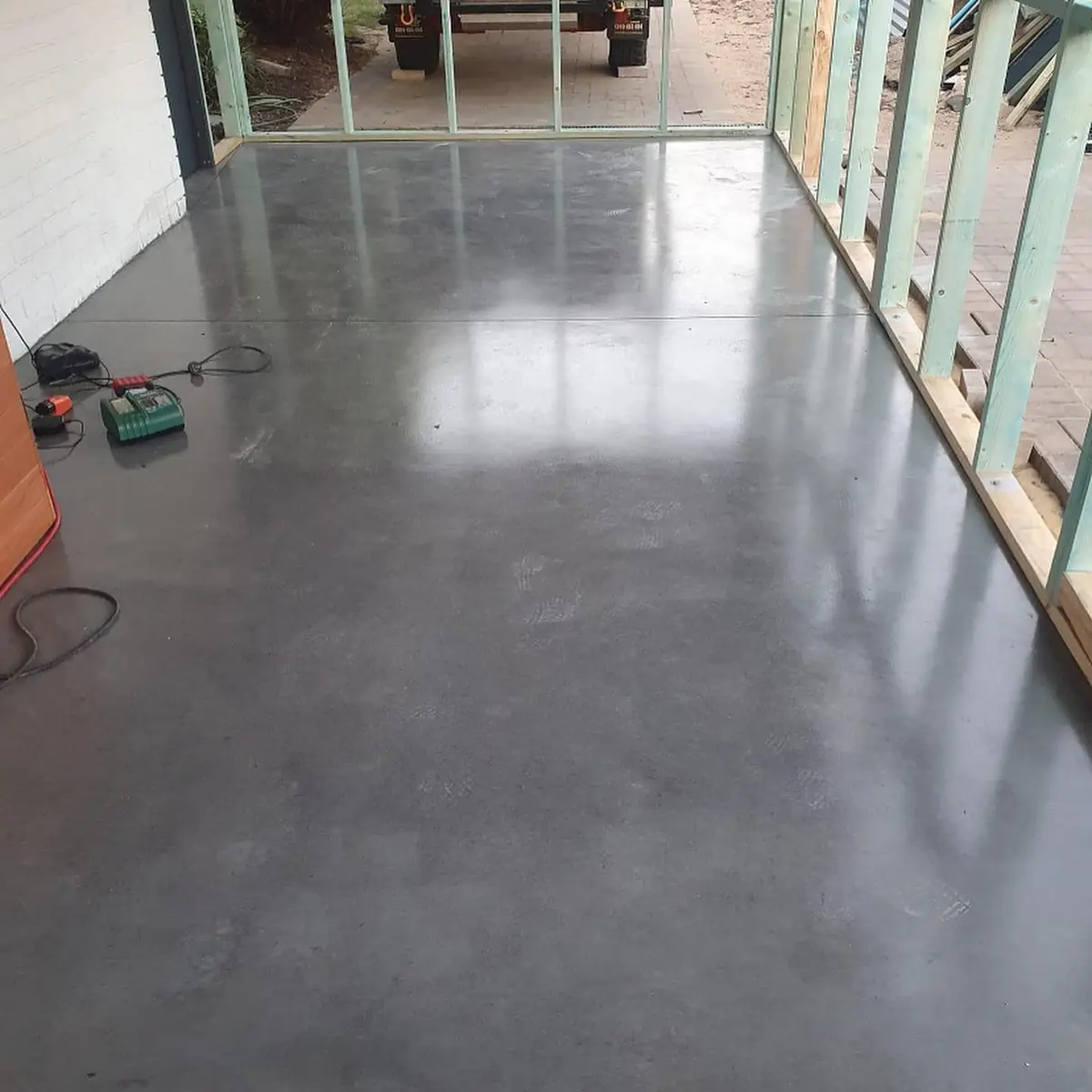 Burnished grey concrete floor inside a house that is still at frame stage