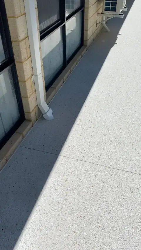 Exposed aggregate side path along a limestone block house